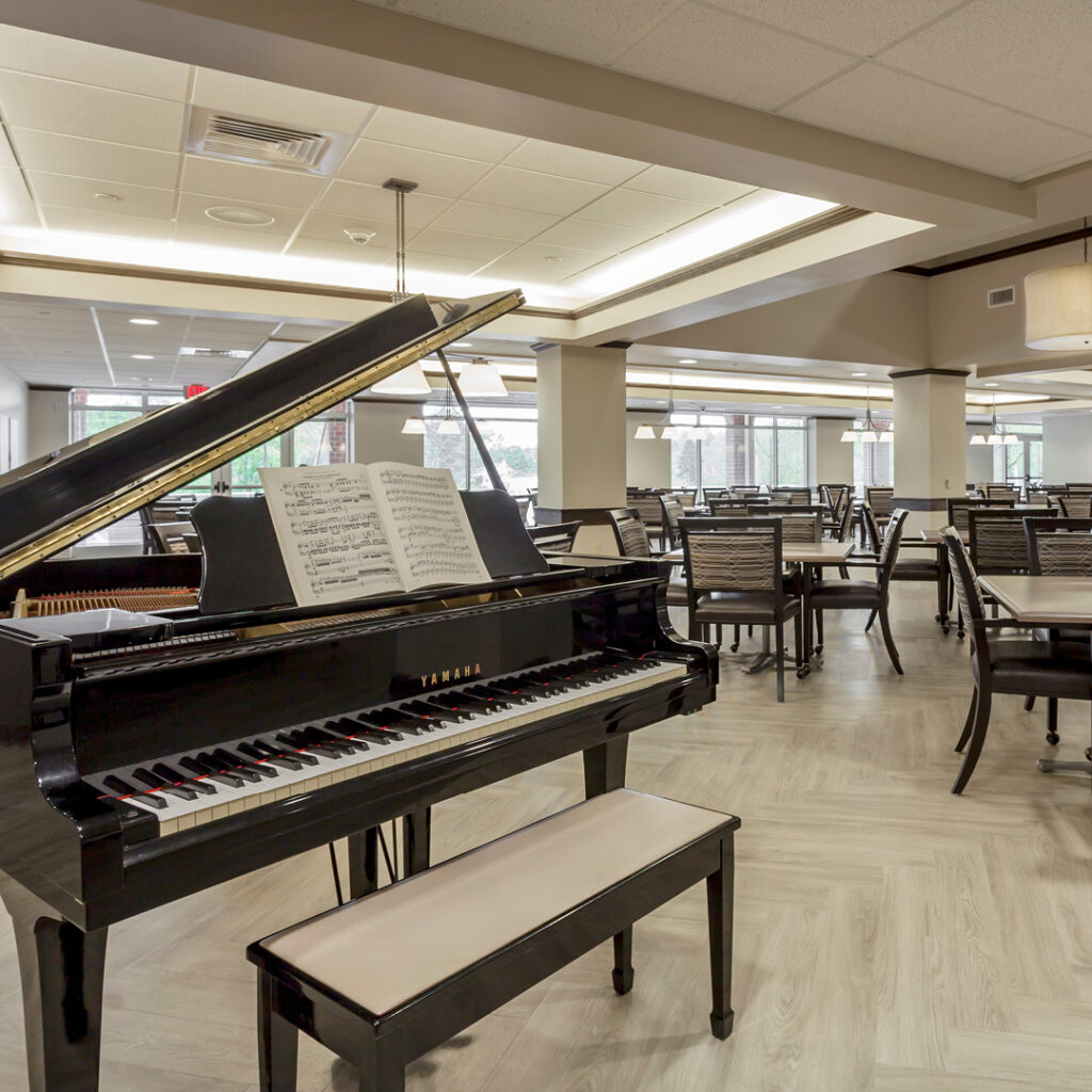 A baby grand piano sits on display in the dining room.