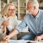 April 25 Events Page Image - The Residence at Bethel Park Elderly man and woman smiling and holding small dog