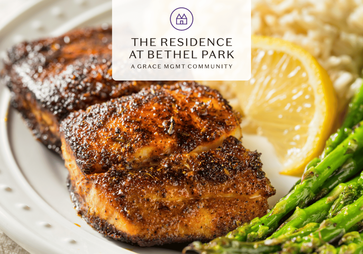 Herb-crusted roasted chicken with a lemon wedge and green asparagus on a plate; logo in the center reading 'The Residence at Bethel Park'.