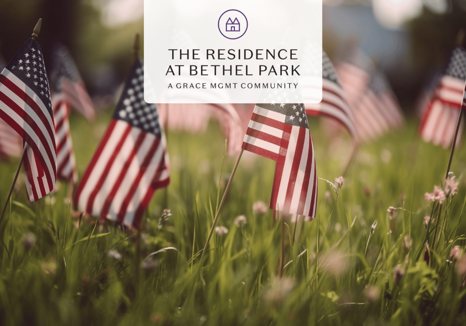 Patriotic scene with American flags waving in a sunlit grassy field and a translucent banner displaying 'The Residence at Bethel Park' logo at the center.